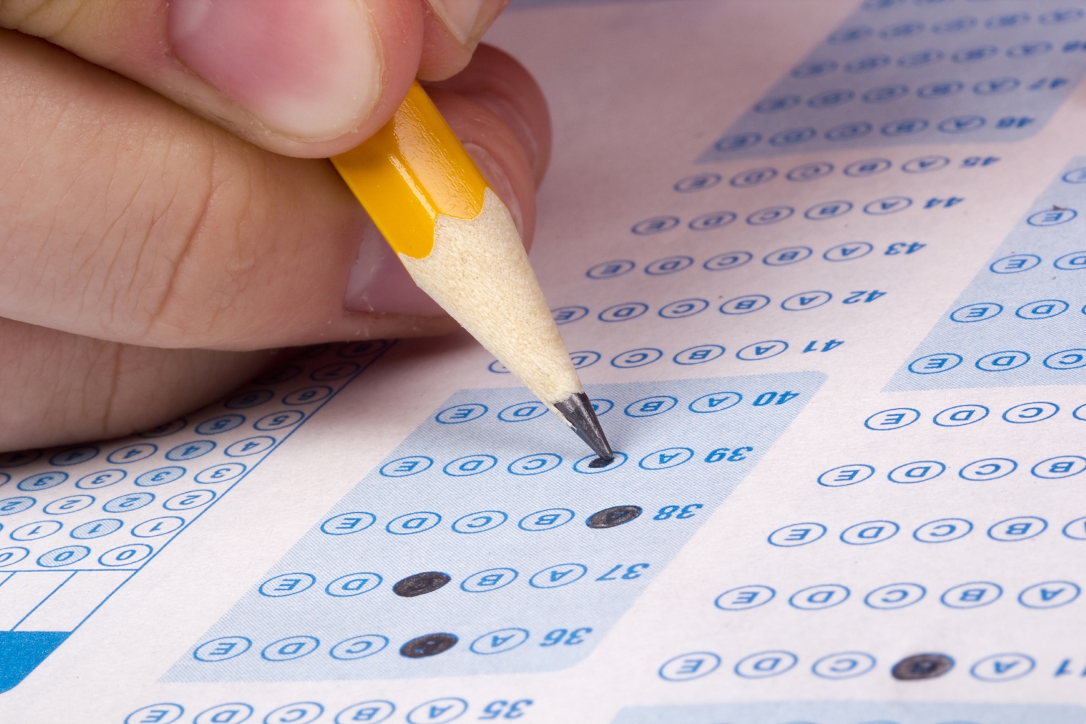 Student filling out answers to a test with a pencil.